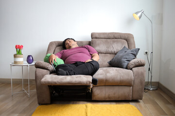 Obraz premium Fat Man Enjoys Relaxing Nap on Sofa with Pillows in His Cozy Living Room