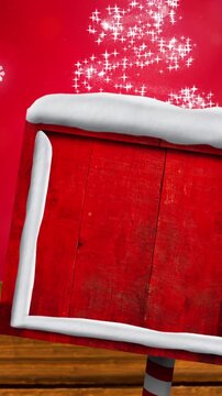 Animation of road sign with copy space over snow falling and glowing spots on red background