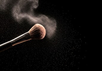 Makeup brush applying powder with delicate cloud against black background