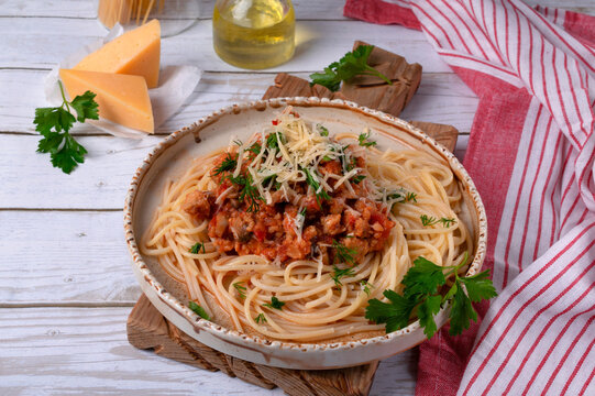 Bolognese pasta with haddock fish mince served with parmesan cheese on ceramic plate. Pescatarian meal. Variation of the classic Italian dish