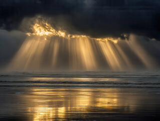 Dramatic golden sunlight beams breaking through thick dark clouds over a calm ocean shore reflecting warm light on wet sand at dusk