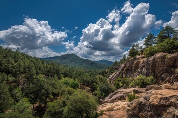 Serene Payson AZ Landscape: Majestic Mountains Under a Blue Sky Surrounded by Lush Forests and Gentle Clouds
