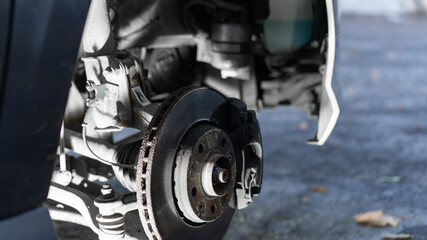 removed wheel in a station wagon car. brake disc, fuel filter replacement. close-up, night light