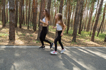 Obraz premium Happy active mother and child jogging outdoors, running in forest
