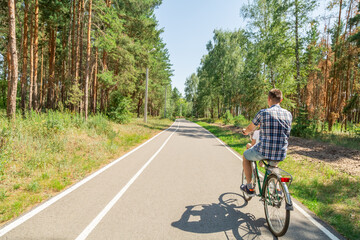Obraz premium Young father with his little daughter on bicycle in summer sunny forest