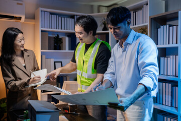 Architects and engineers work together in an office to review blueprints, exchange ideas, and refine their building plans for a contemporary construction project in an urban setting.