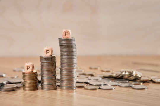 Stacks of coins with wooden cubes showing PPE letters (Employee Pension Program) symbolizing Polish workplace pension savings and financial growth