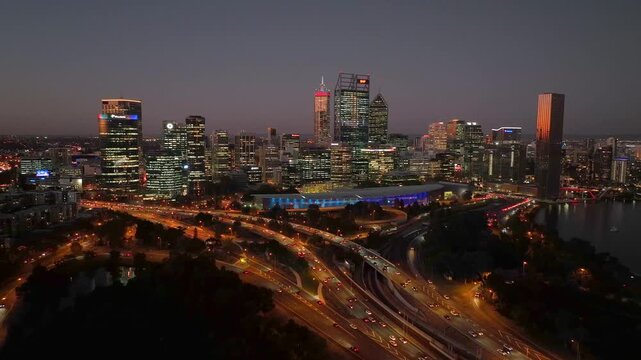 Aerial view of Perth's illuminated skyline, roads and buildings at dusk create a mesmerizing tapestry of light and shadow, Perth, Western Australia, Australia.