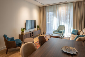 Home interior design with beige sofa, blue chair, and traditional carpet