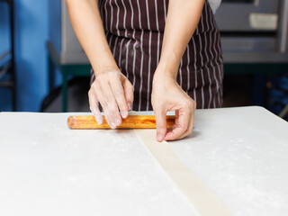 Close-up hand of asian young woman rolling dough into rolls with butter for homemade bread cooking on table in kitchen home, preparation ingredients desserts process making buns manually bakery baking