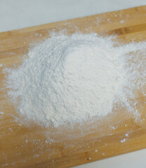 Top view, picture frame of baking pastry or cake ingredients for bread bakery, flour, yeast, water, butter on wooden cutting board on a white table, homemade preparation process making cooking concept