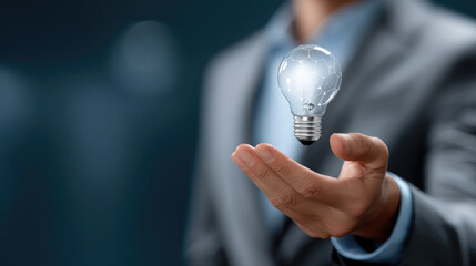 Naklejka na ściany i meble Businessman holding glowing light bulb innovation concept, creative idea, futuristic technology, inspiration, success, modern business Naklejka na ściany i meble Businessman holding glowing light bulb innovation concept, creative idea, futuristic technology, inspiration, success, modern business