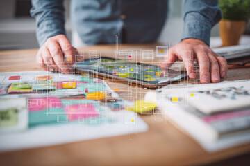 Obraz premium Creative technology professional using digital tablet and paper sketches, innovative design process with floating neon circuits, modern workspace, focus and inspiration