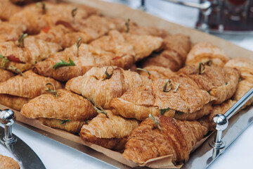 Set of coffee break in the hotel during conference meeting, with tea and coffee catering, decorated catering banquet table with variety of different pastry and bakery, with croissants, pie and cookies