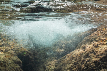 Clear Mediterranean seawater bubbles over underwater rocks covered in algae at beautiful Saint-Jean-Cap-Ferrat, French Riviera, France.
