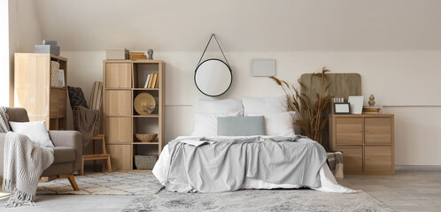 Comfortable modern bedroom with armchair and mirror