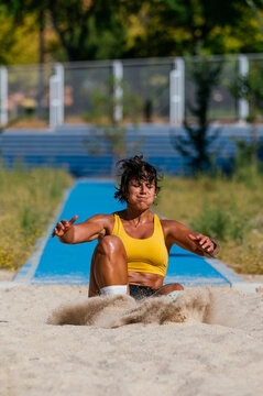 Athlete landing in sand after a long jump attempt