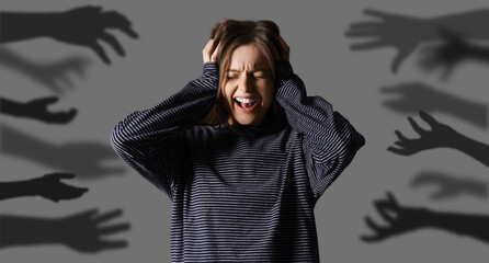 Young woman having panic attack on dark background