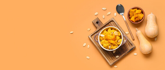 Pot of tasty millet porridge with pumpkin and ingredients on orange background