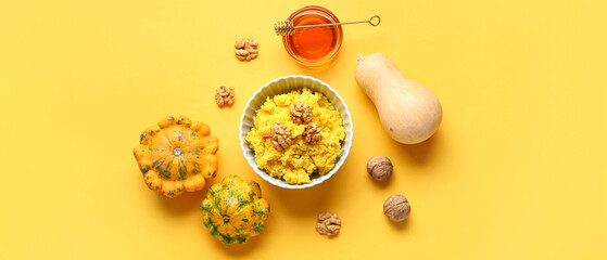 Bowl of tasty millet porridge with pumpkin and ingredients on orange background