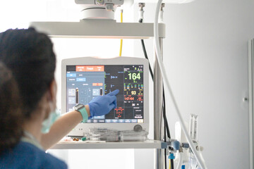 Nursing assistant monitoring ICU patient data