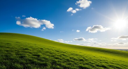 Obraz premium Vibrant Green Hill Under a Bright Blue Sky with Fluffy White Clouds and Sun.