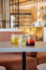 Mojito, lemonade and cherry-strawberry cocktails in glass glasses stand on a restaurant table. Cocktail set