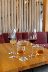 Cocktail of whiskey, scotch, brandy, wine and lemonade in glass glasses on a restaurant table. Bar set of cocktails for a party