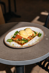 Toast with eggs benedict red fish and spinach. Breakfast lunch and dinner in a restaurant