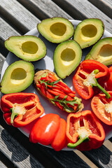 Avocado toast with red pepper and fresh avocados and sliced ​​peppers on the table