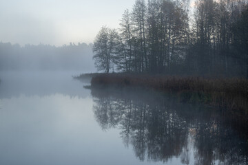 early morning by the lake, light fog over the water, trees around in autumn colors, nature in autumn © ANDA