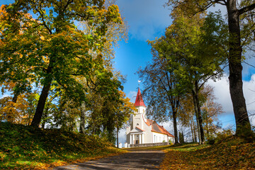 landscape with a white country church, trees around in autumn colors, wonderful nature in autumn,...