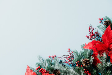 Merry Christmas card design. Festive corner with poinsettia, frosted pine, berries and cones on...