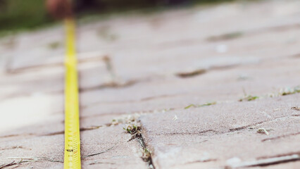 Measuring a Paved Surface with a Yellow Tape Measure