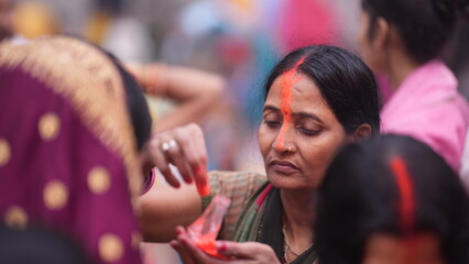 Married woman celebrates Chhath Puja by applying sindoor on forehead after Usha Arghya, representing purity and divine blessings.