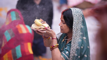 Woman giving Arghya to Chhathi Maiya during Chhath Puja sunrise ritual, offering prayers in holy water with deep faith and devotion.