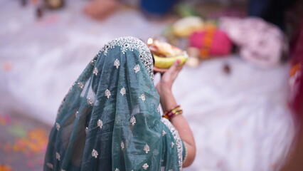 Devotee woman offering Arghya to Chhathi Maiya during morning Chhath Puja, expressing purity, devotion, and spiritual peace.