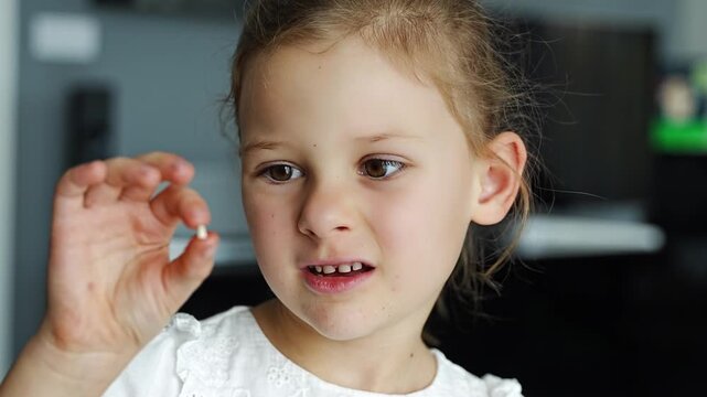 Smiling girl proudly shows her lost baby tooth, focus on joyful face. Celebration of childhood milestone and emotional development moment.