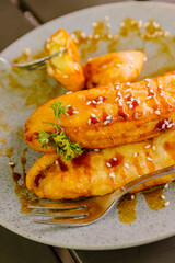 Extreme close-up of crispy fried banana (Pisang Goreng) dessert, generously drizzled with rich, glossy, and sticky caramel sauce on top