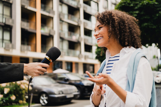 Young woman smiles during street interview in a lively urban city setting