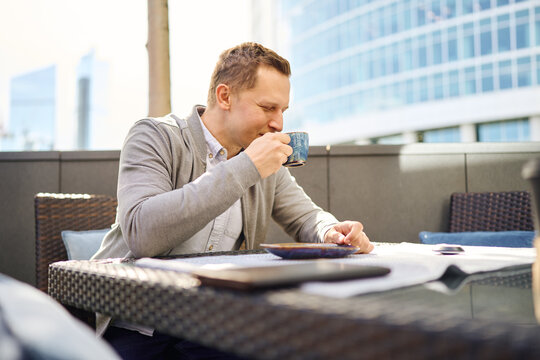 Man taking a coffee break in sunny outdoor office setting