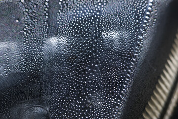 Calm macro shot of water drop condensation. wet dew forms on dark abstract background surface....