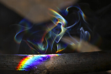 Abstract colorful rainbow smoke rising against dark background. Ethereal light spectrum creating...
