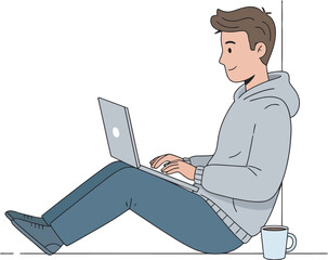 A young man sits leaning against a wall, working on a laptop computer.