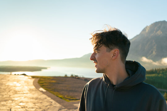 A man gazes over the landscape during sunrise, appreciating its beauty.