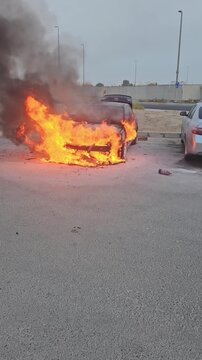  A Blake car in an industrial area is on fire. The engine compartment is on fire, 