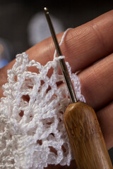 Close-up photo of crocheting a delicate white lace angel. Handmade eco-friendly Christmas...