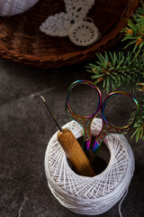 Top view of crochet tools and yarn in a basket on rustic wooden table. Cozy handmade workspace...