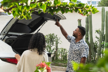 Young couple closing car trunk after travel vacation © Hector Pertuz