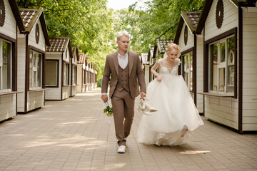 Couple strolls through resort pathway after outdoor wedding ceremony